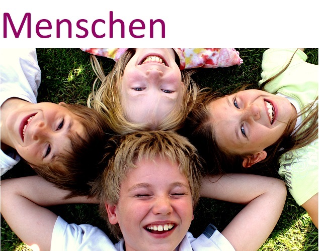 Kinder liegen mit den Köpfen zusammen auf dem Rücken im Gras